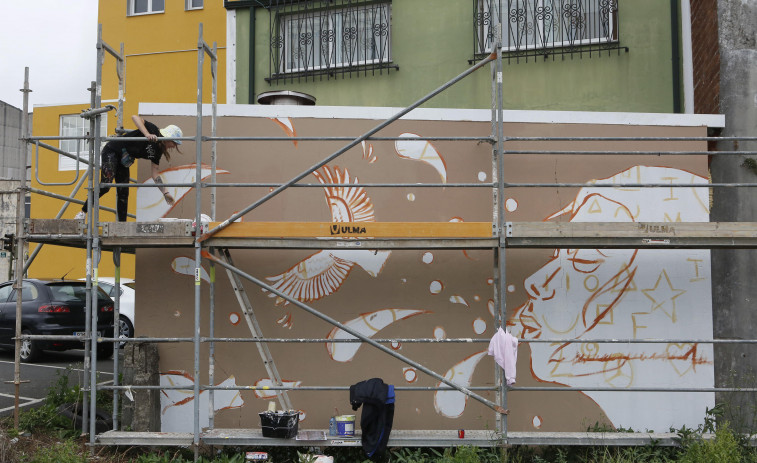 Las ganas de derrumbar muros con pintura en Carballo pueden más que la lluvia