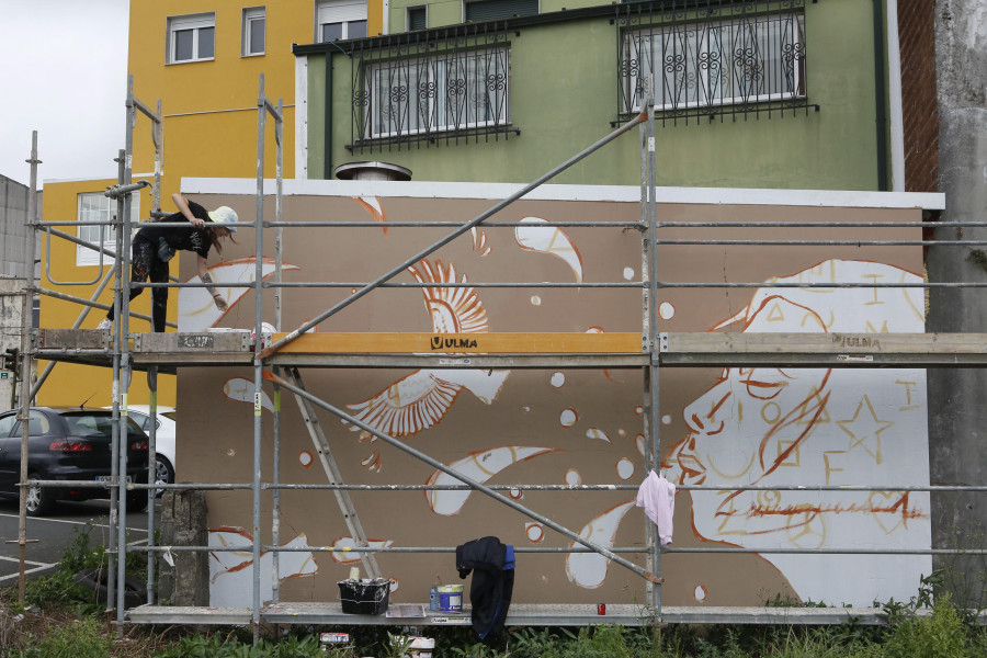 Las ganas de derrumbar muros con pintura en Carballo pueden más que la lluvia