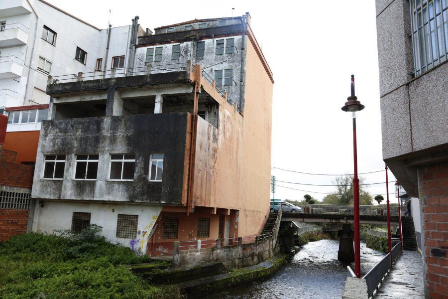 El edificio que invade el río en la calle Sol de Carballo tiene los días contados