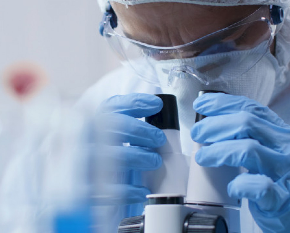Primer plano medico cientifico mirando al microscopio medico que analiza muestra sangre experimento cientifico laboratorio bioquimica hombre investigador desarrollando vacuna contra covid19