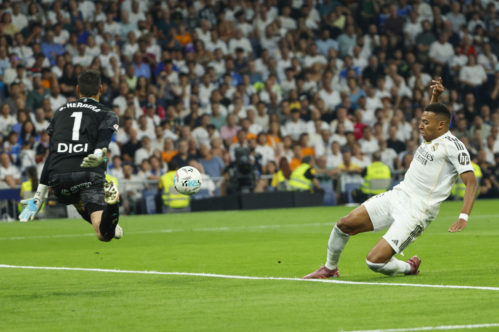 El delantero francés del Real Madrid, Kylian Mbappé (d), intenta un lanzamiento en el partido